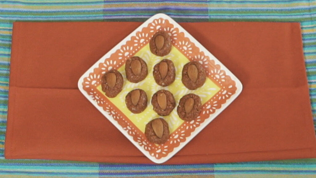 Cranberry almond energy bites arranged on a square orange and yellow plate.
