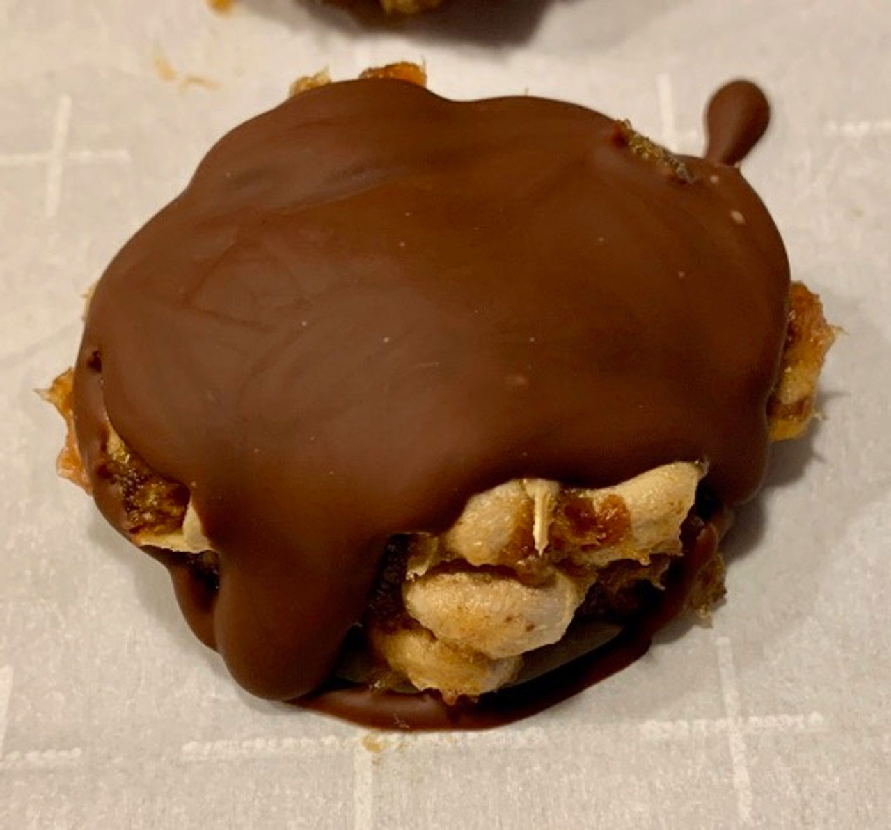 A closeup of a Tosted cluster covered with a date and chocolate coating.