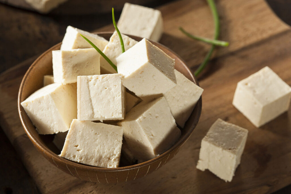 A bowl filled up with cut squares of tofu.
